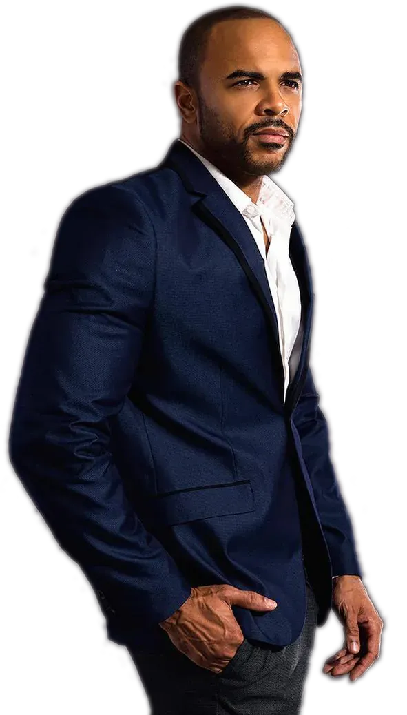 Donavan Wheatfall in a navy suit, one hand in his pocket